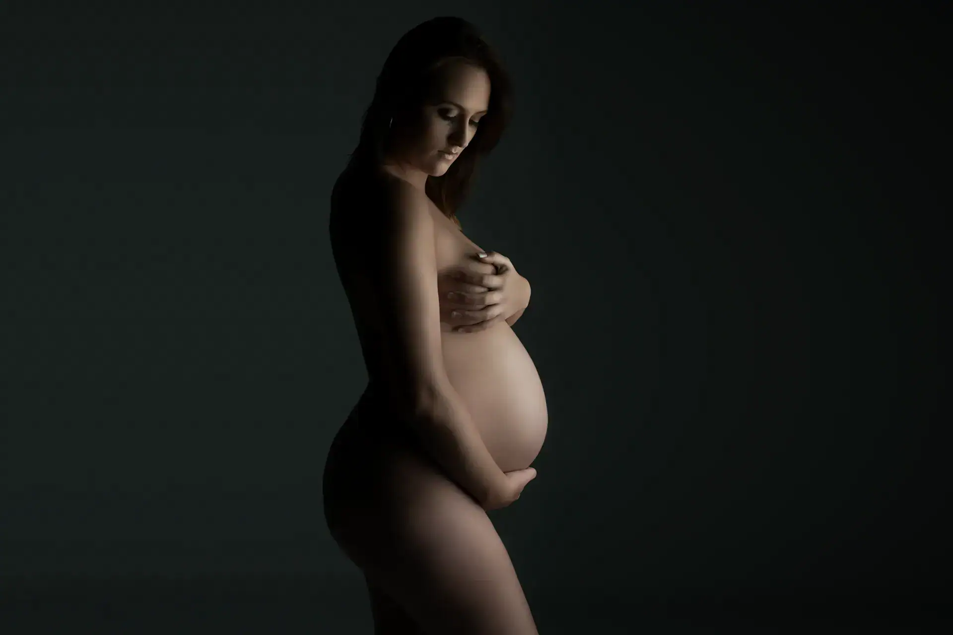 Artistic Maternity Photography Johannesburg Pregnant woman photographed in a sculptural fine art maternity portrait against a dark studio background
