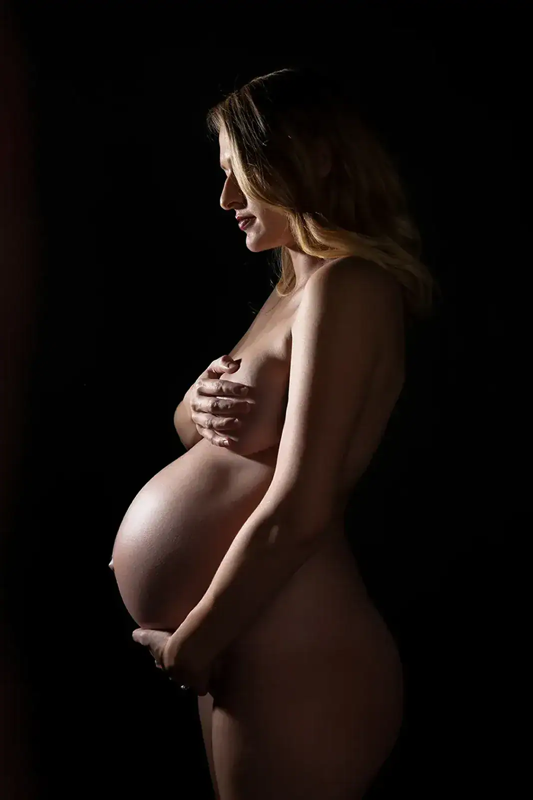 Artistic Nude Maternity Silhouette Side profile artistic nude maternity portrait using dramatic low key studio lighting