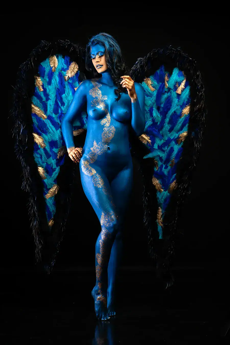 Blue Angel Body Paint with Feather Wings Blue body painted woman posing with dramatic feather wings in a theatrical fine art portrait