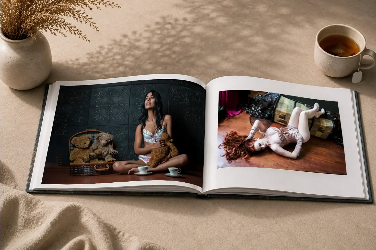 Luxury Boudoir Coffee Table Book Open photo album on a beige surface; left image shows a woman in lingerie with teddy bears, right image a woman in pink lingerie on the floor.