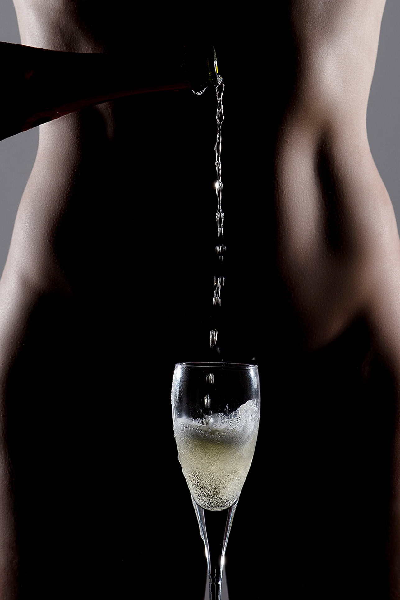 Champagne Pour Conceptual Body Art Champagne pouring between a woman's body into a glass in a graphic conceptual photograph