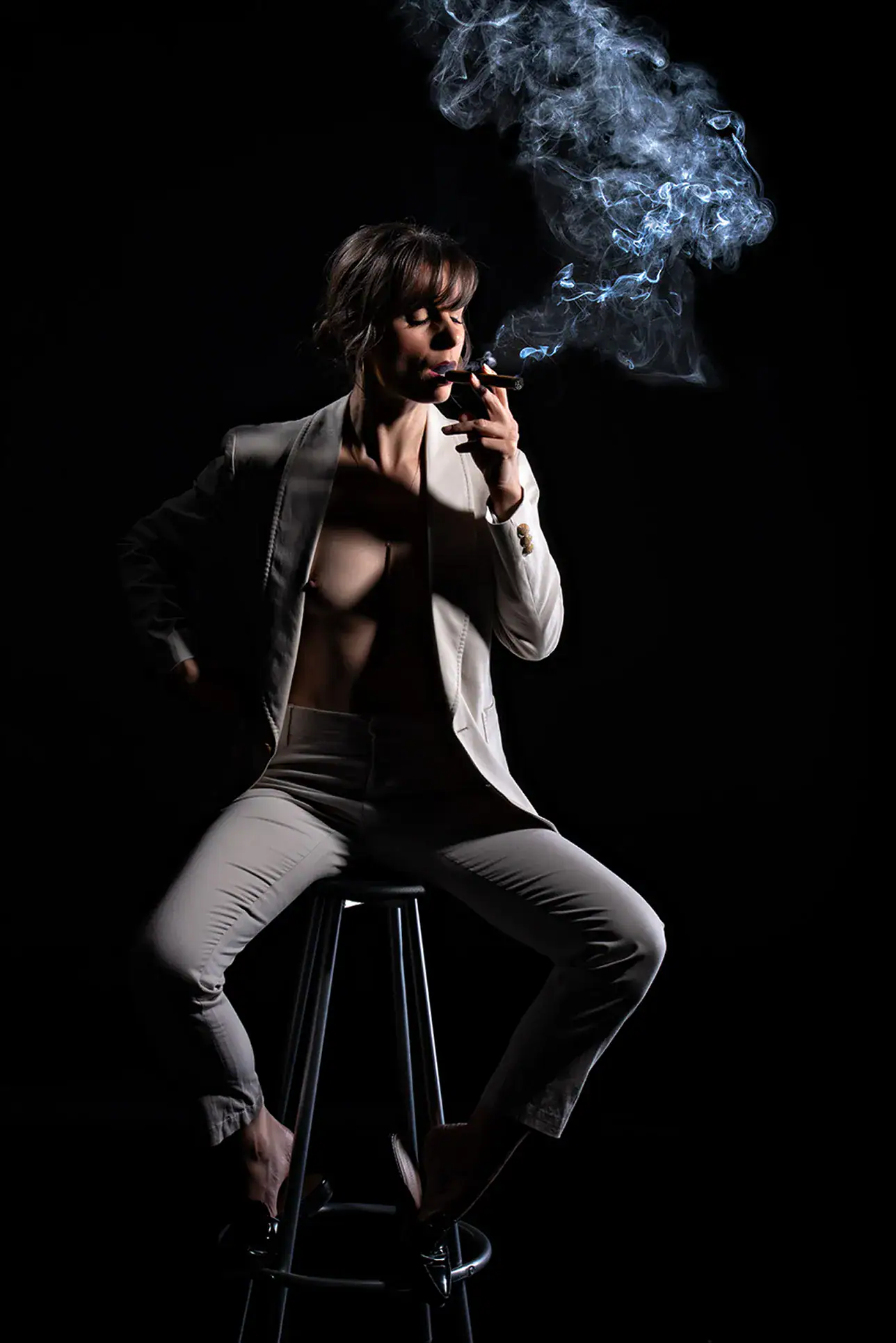 Cinematic Smoking Character Portrait Woman in tailored clothing surrounded by curling smoke against a black studio background