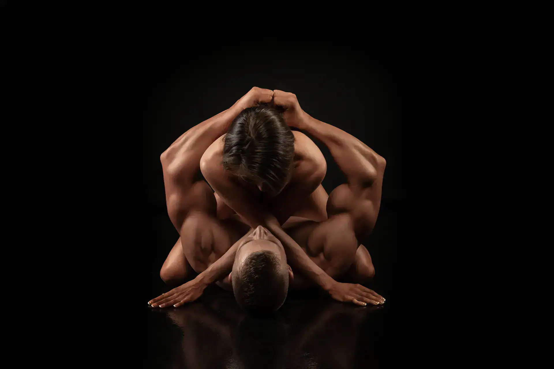 Fine Art Nude Couple Embrace Fine art nude portrait of a couple embracing, sculpted by dramatic low key studio lighting.