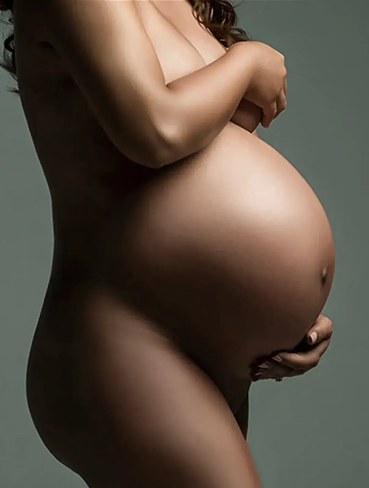 Intimate Maternity Bodyscap Close up maternity bodyscape highlighting the shape of a pregnant belly in soft studio light