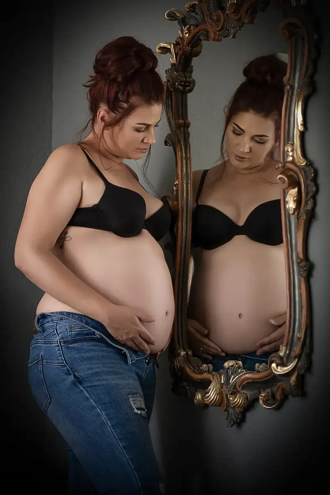 Maternity Portrait with Mirror Reflection Pregnant woman in black lingerie photographed beside an ornate mirror during a maternity photoshoot
