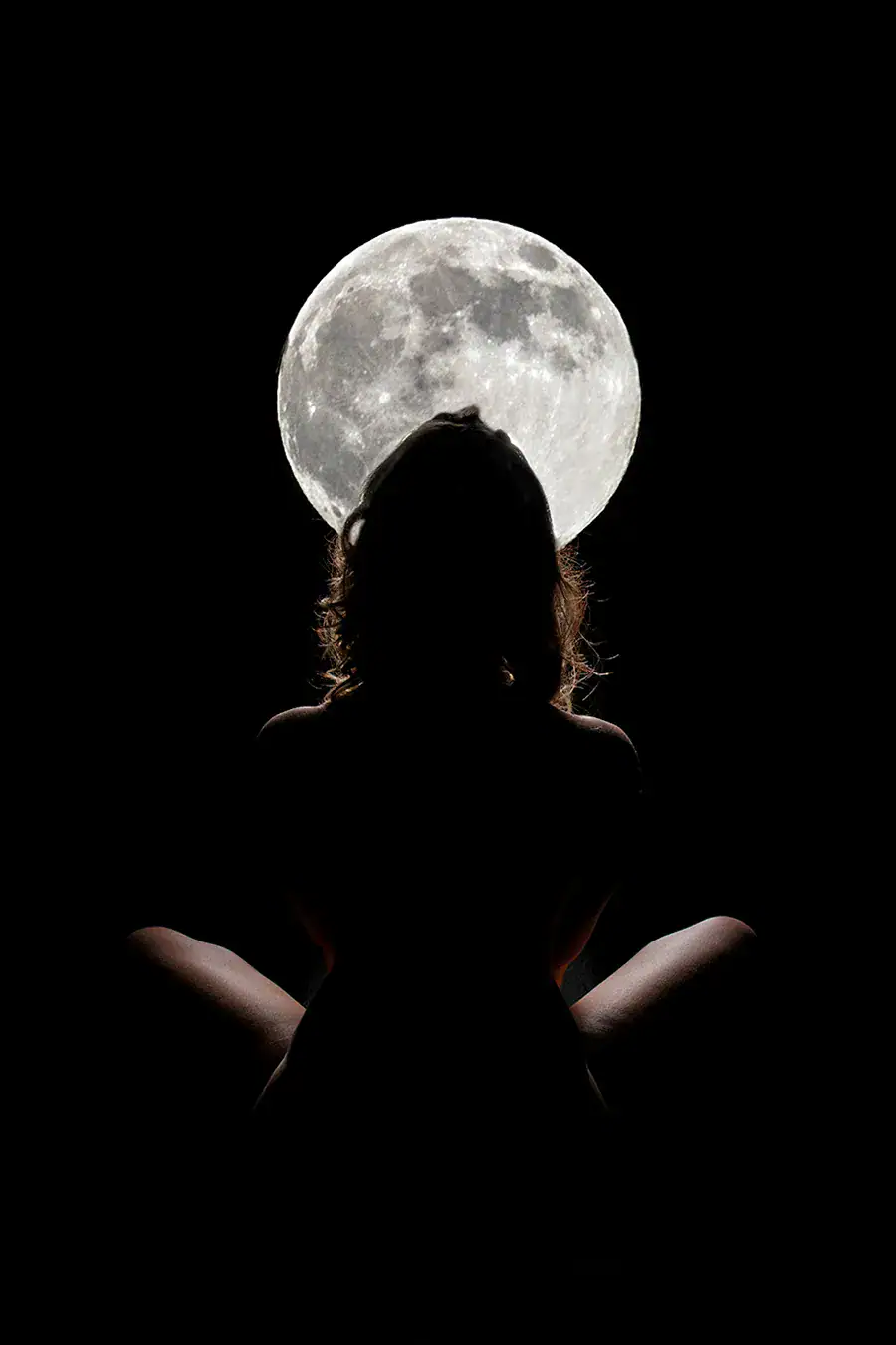 Moon Silhouette Conceptual Photography Silhouetted woman posed against a full moon in a dark conceptual portrait