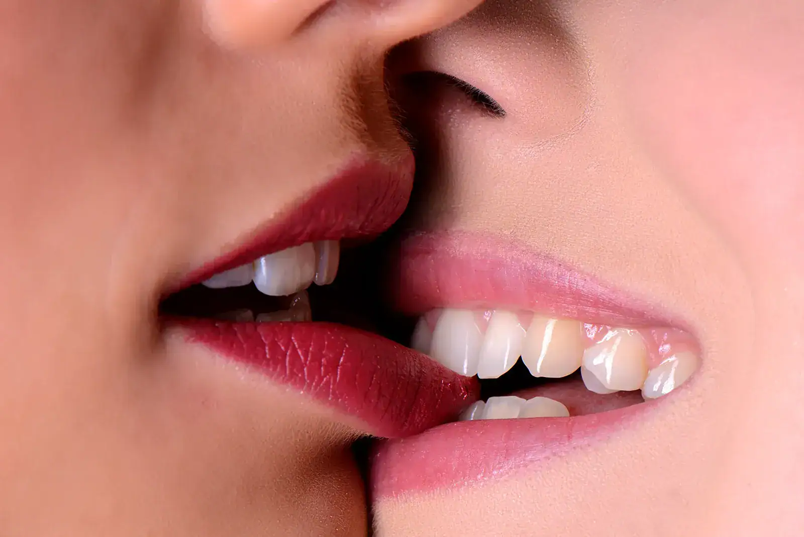 Sensual Bite Close up of two women sharing a playful bite, creating a suggestive and intimate erotic photograph.